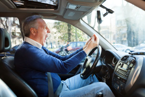 man screaming in his car